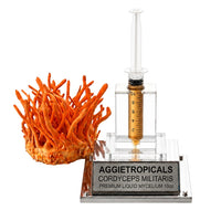 A cluster of Cordyceps militaris mushrooms with orange, finger-like fruiting bodies, beside a syringe filled with liquid mycelium culture mounted on a mirrored stand, labeled "AGGIETROPICALS, CORDYCEPS, PREMIUM LIQUID MYCELIUM 10cc", on a white background.