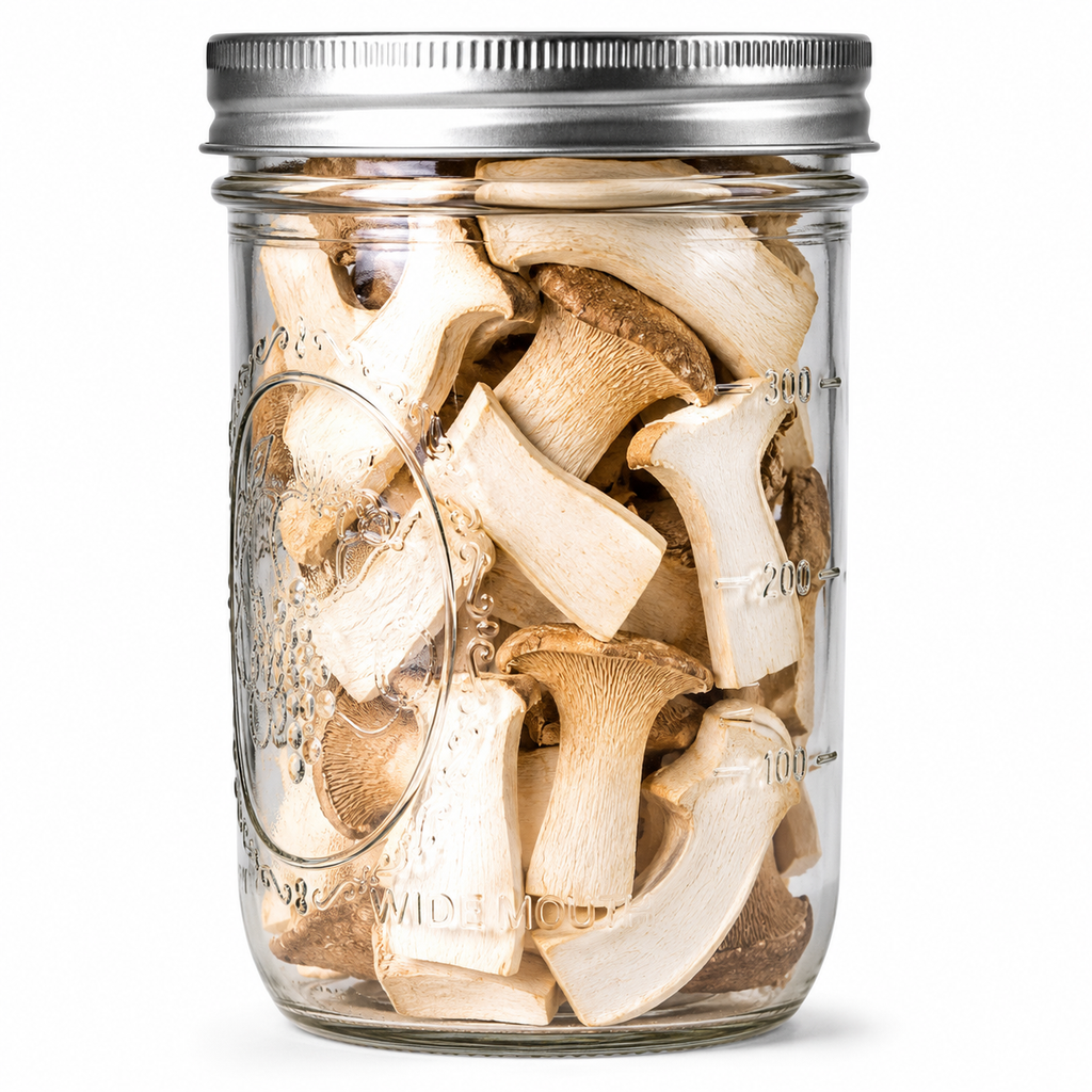 A clear glass mason jar with a silver metal lid, filled with sliced dried mushrooms, shown against a plain white background.