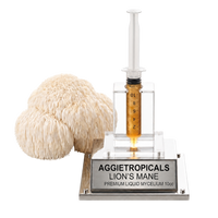 A lion's mane gummies product display featuring a clear plastic syringe filled with golden amber liquid mounted on a clear acrylic stand with a silver base labeled 'AGGietropicals LION'S MANE PREMIUM LIQUID MYCELIUM 10cc'. A large beige lion's mane mushroom is positioned to the left of the stand against a solid white background.
