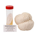 A rounded Lion's Mane mushroom formed of cascading white icicle-like spines, beside a clear 50ml centrifuge tube containing a slanted agar culture with white mycelial growth, labeled "AGGIETROPICALS CULTURE BANK, LION'S MANE MUSHROOM SLANT CULTURE, 50ml Centrifuge Tube, Agar: MEA (Malt Extract Agar)", on a white background.