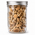 A clear glass mason jar with a silver metal lid, filled with dried brown mushrooms, shown against a plain white background.